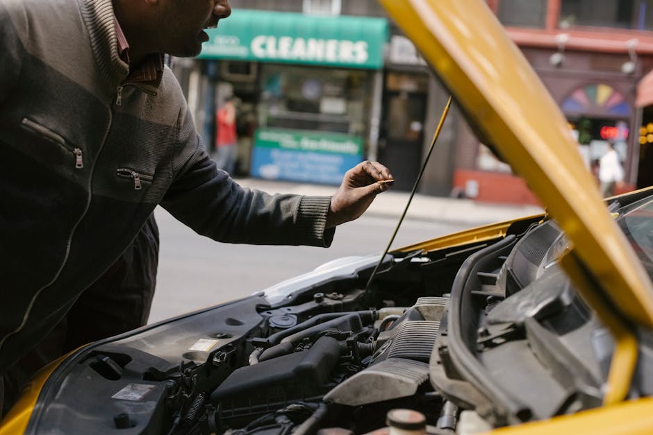 Persona escuchando el motor de un auto con el capó abierto